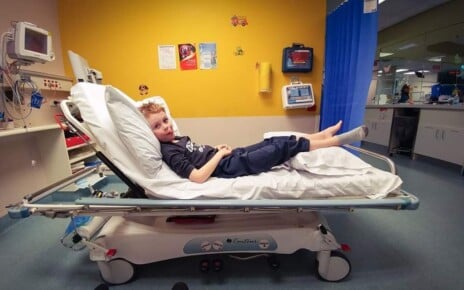 A young Ethan lies in a hospital for his Juvenile Idiopathic Arthritis